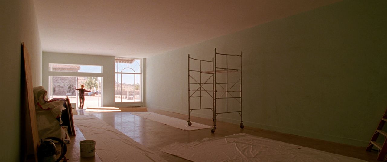 Empty commercial interior mid-renovation with scaffold under a high ceiling