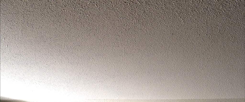 Close view of heavy popcorn ceiling texture in raking light